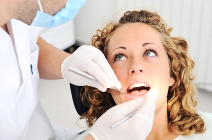 Young woman getting her teeth examined by a dentist