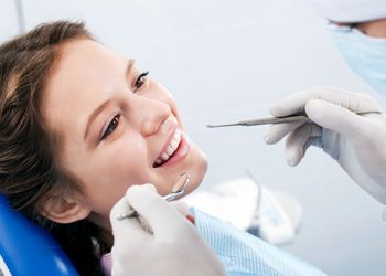 Young woman getting her teeth examined by a dentist